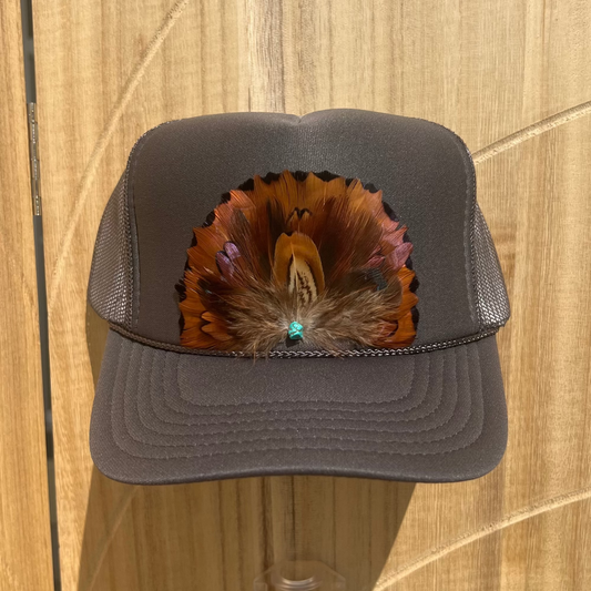 Gray cap with feather design on a wooden surface