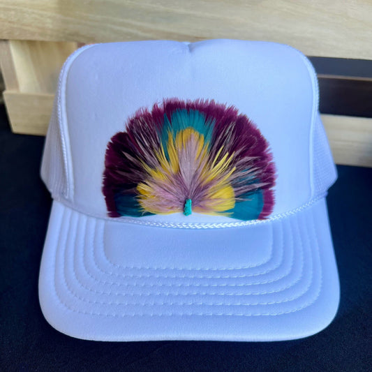 White cap with a colorful feather design on a dark surface