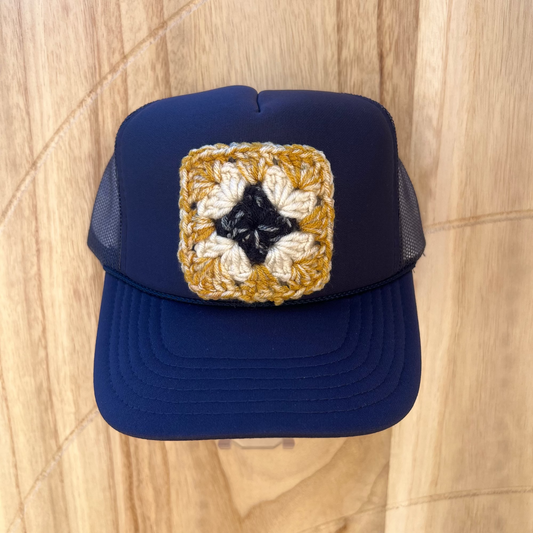 Blue cap with a decorative patch on a wooden surface
