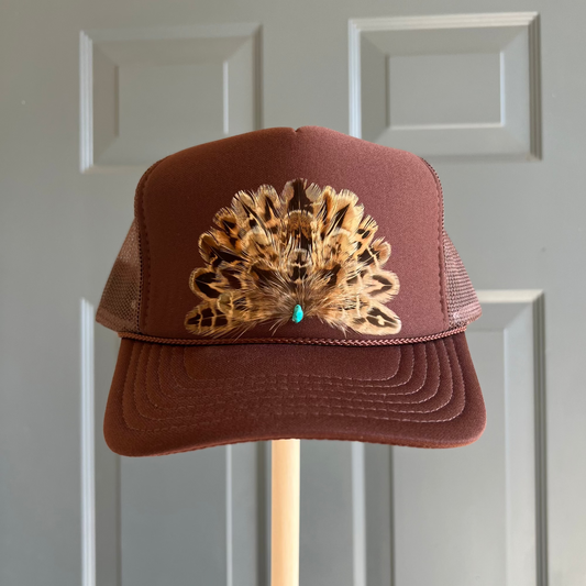 Front view of Volant Style trucker hat in brown featuring hand-placed tan brown feathers with a center turquoise stone.